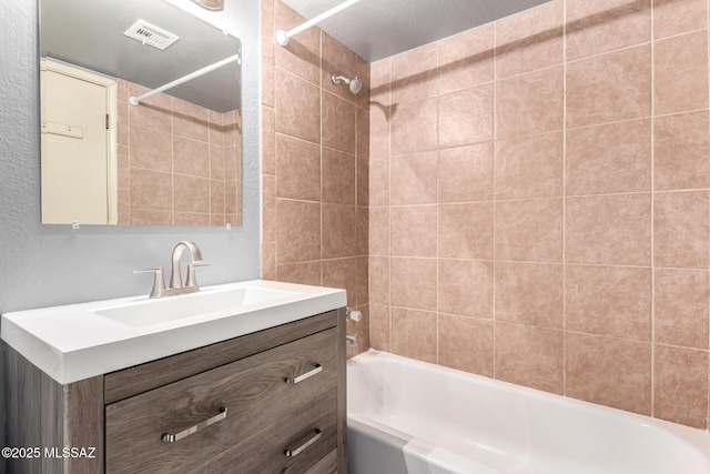 bathroom featuring vanity and tiled shower / bath