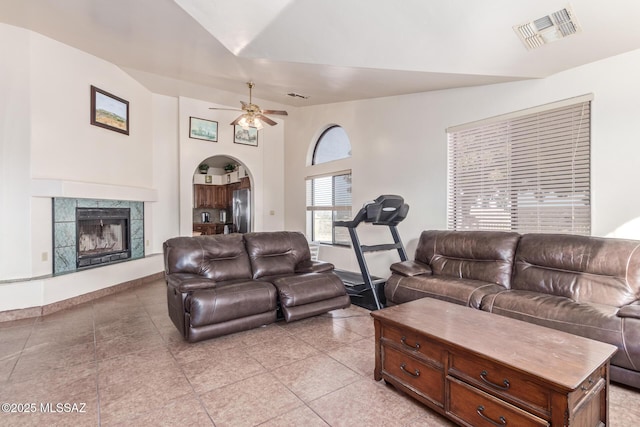 living room featuring ceiling fan, light tile patterned floors, and a tiled fireplace