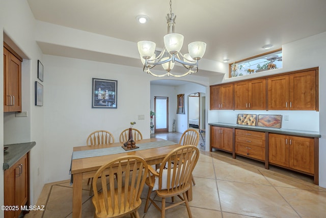 tiled dining area featuring a chandelier