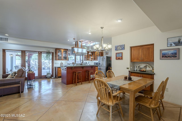 dining space with light tile patterned floors, an inviting chandelier, and french doors