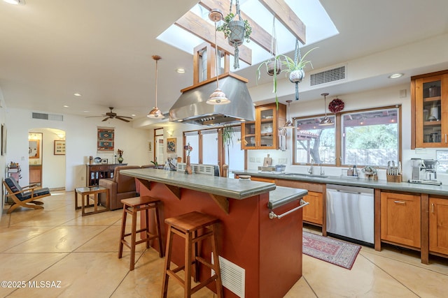 kitchen featuring light tile patterned flooring, a breakfast bar, sink, dishwasher, and an island with sink