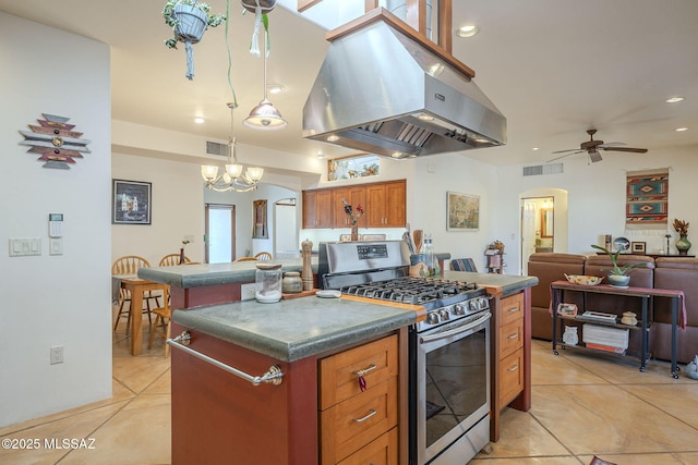 kitchen with a kitchen island, pendant lighting, island exhaust hood, light tile patterned floors, and stainless steel range with gas stovetop