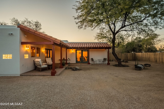 back house at dusk with a patio