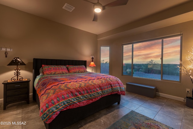 bedroom with ceiling fan, tile patterned flooring, and multiple windows