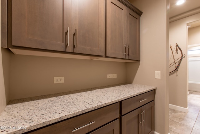 interior space with light stone countertops and light tile patterned floors