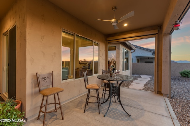 patio terrace at dusk with a mountain view and ceiling fan