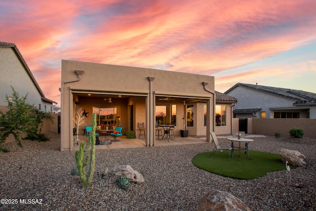 back house at dusk with a patio area