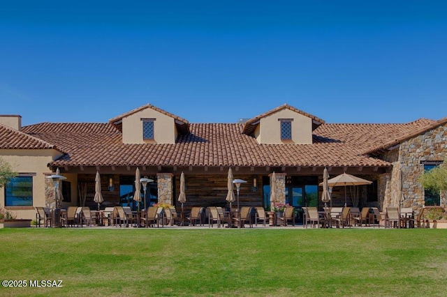 rear view of property featuring a lawn