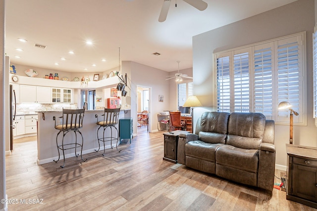 living room with light hardwood / wood-style flooring and ceiling fan