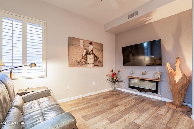 living room featuring ceiling fan and light hardwood / wood-style floors