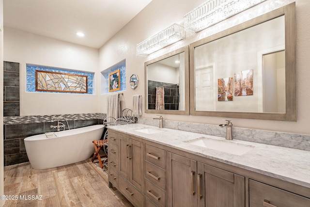 bathroom with vanity, hardwood / wood-style floors, a tub, and tile walls