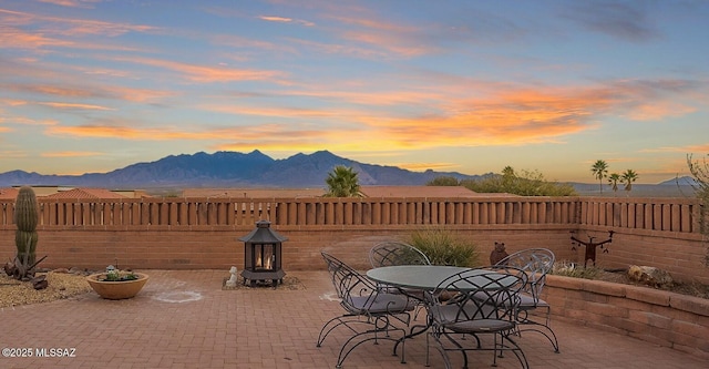 patio terrace at dusk featuring a mountain view