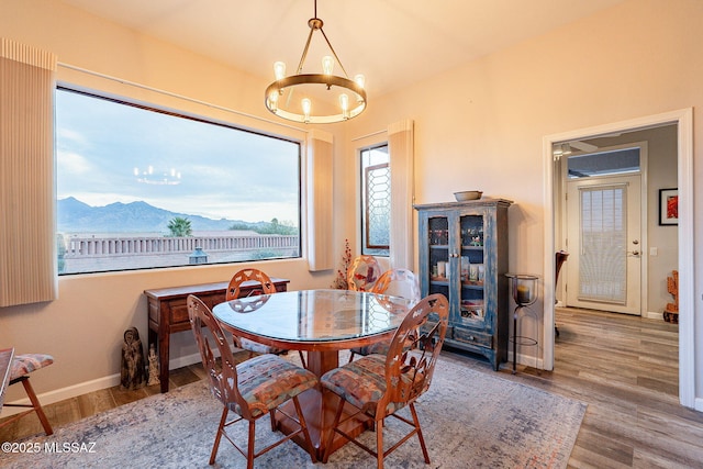 dining space with hardwood / wood-style flooring, a mountain view, and a chandelier