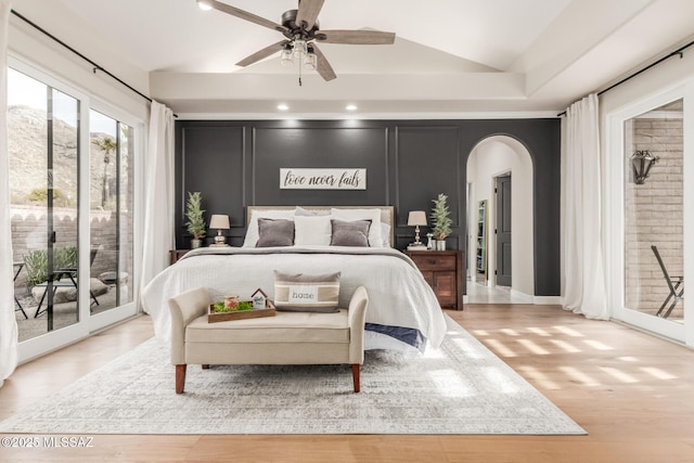 bedroom featuring ceiling fan, lofted ceiling, light hardwood / wood-style flooring, and access to outside