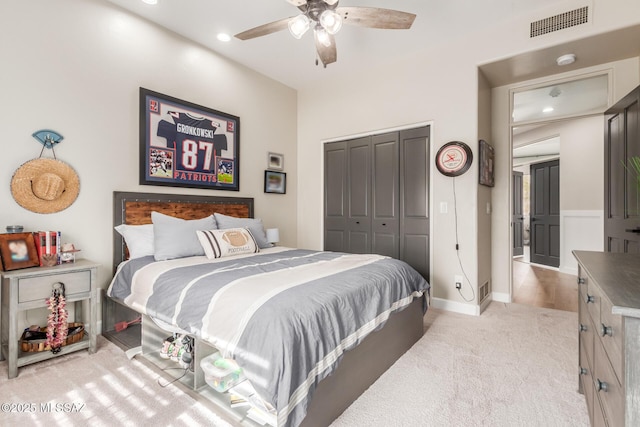 bedroom featuring light carpet, a closet, and ceiling fan