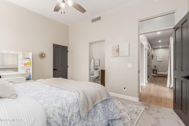 bedroom featuring ceiling fan, light hardwood / wood-style floors, and ensuite bath