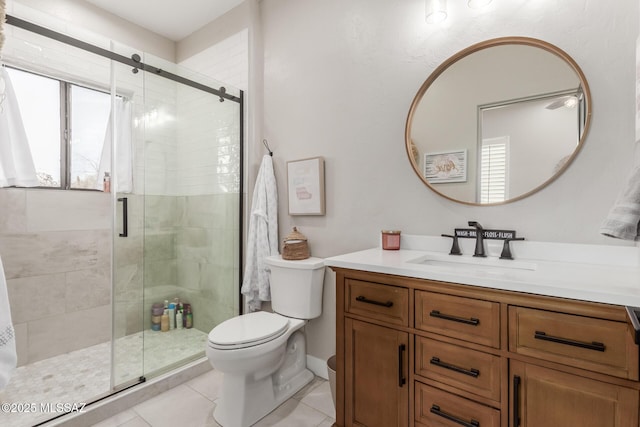 bathroom with toilet, tile patterned flooring, a shower with shower door, and vanity