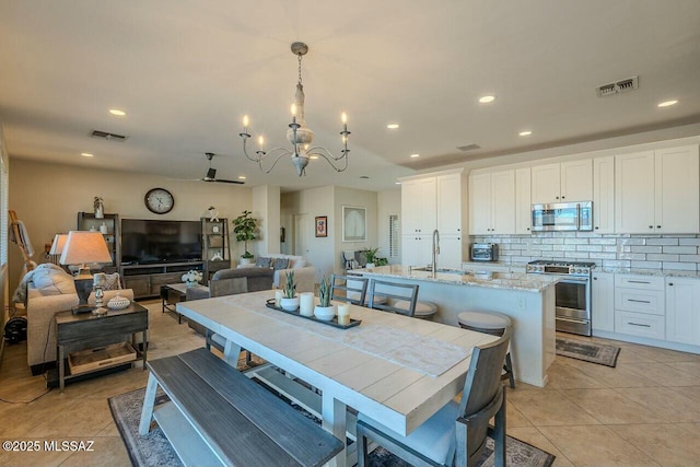 dining space featuring visible vents, recessed lighting, light tile patterned floors, and an inviting chandelier