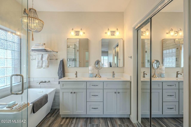 bathroom featuring a freestanding tub, double vanity, and a sink