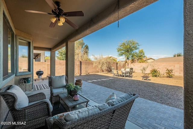 view of patio with outdoor lounge area, outdoor dining space, a fenced backyard, and a ceiling fan