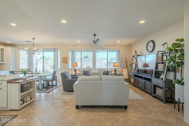 living room featuring light tile patterned flooring, visible vents, recessed lighting, and ceiling fan with notable chandelier