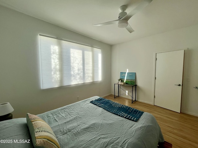 bedroom with light hardwood / wood-style floors and ceiling fan