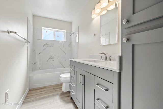 full bathroom featuring wood-type flooring, tiled shower / bath combo, vanity, and toilet