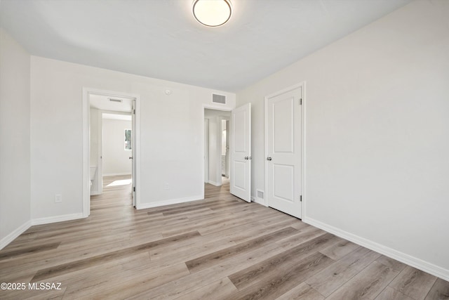 unfurnished bedroom with a closet and light hardwood / wood-style flooring