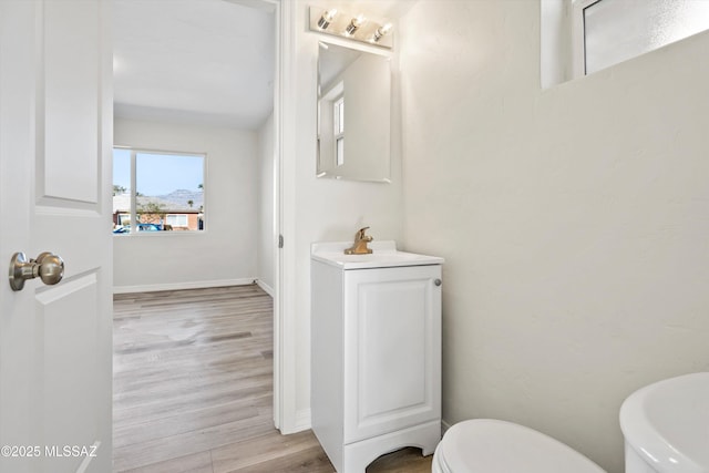 bathroom featuring wood-type flooring, sink, and toilet