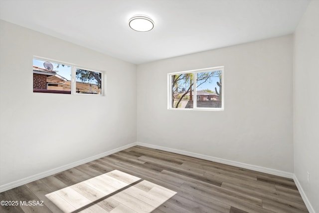 empty room featuring a healthy amount of sunlight and hardwood / wood-style flooring