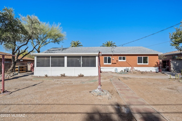 rear view of property featuring a sunroom