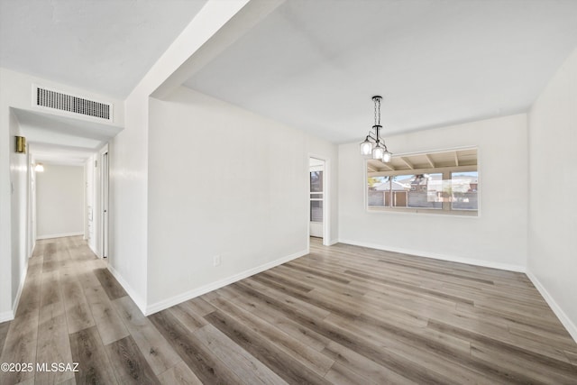 unfurnished dining area with hardwood / wood-style flooring and an inviting chandelier