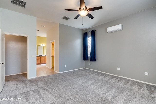 unfurnished bedroom featuring a wall unit AC, light colored carpet, and ceiling fan