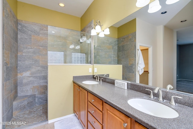 bathroom featuring vanity, tile patterned flooring, and tiled shower