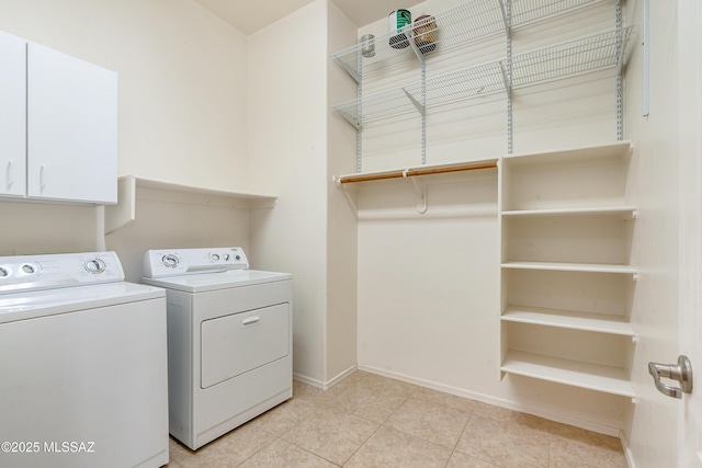 laundry area featuring cabinets, light tile patterned flooring, and washer and dryer