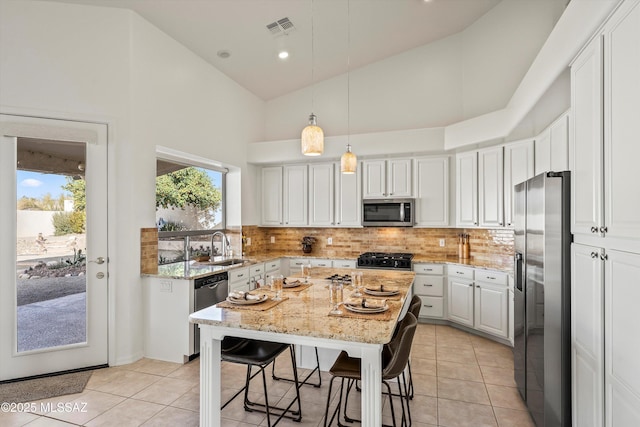 kitchen with high vaulted ceiling, white cabinets, light tile patterned floors, stainless steel appliances, and light stone countertops