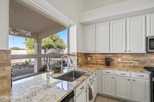 kitchen featuring light stone countertops, sink, white cabinets, and decorative backsplash