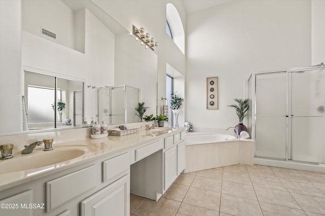 bathroom featuring tile patterned floors, separate shower and tub, vanity, and a high ceiling