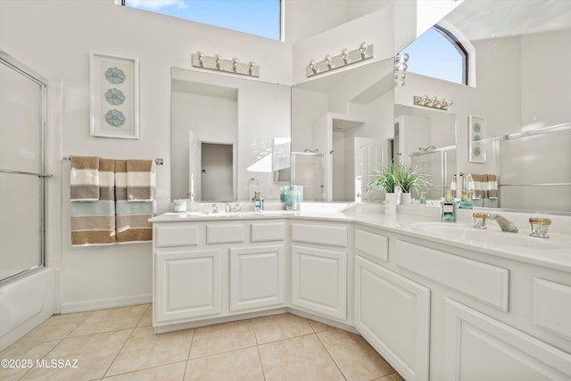 bathroom with tile patterned flooring, vanity, a towering ceiling, and combined bath / shower with glass door