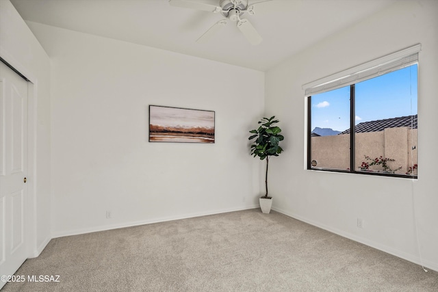 carpeted spare room with ceiling fan