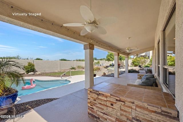 view of patio / terrace with a fenced in pool and ceiling fan