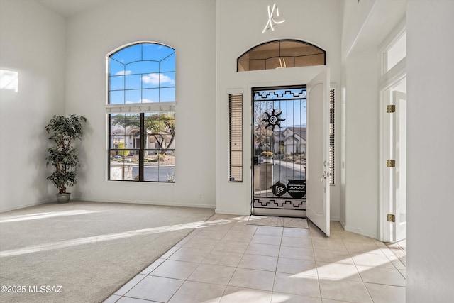 entrance foyer with a high ceiling and light colored carpet