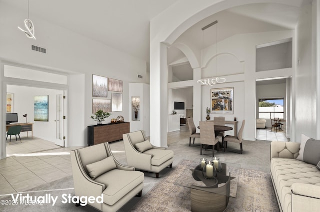 living room featuring light tile patterned floors, a towering ceiling, and built in features