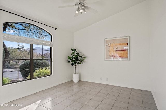 tiled empty room featuring vaulted ceiling and ceiling fan