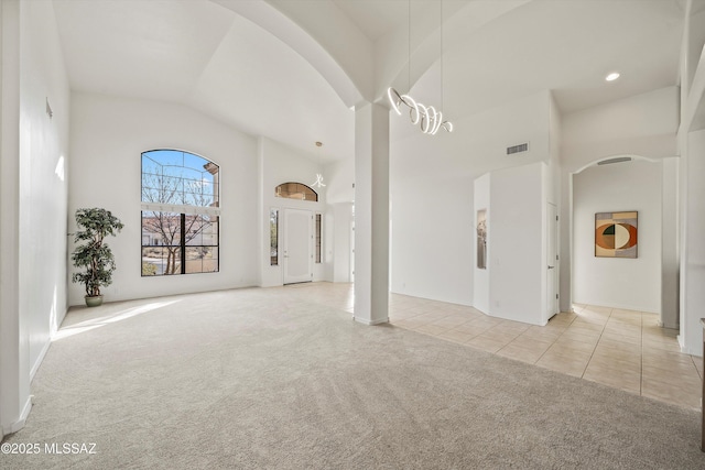 unfurnished living room with light colored carpet and high vaulted ceiling