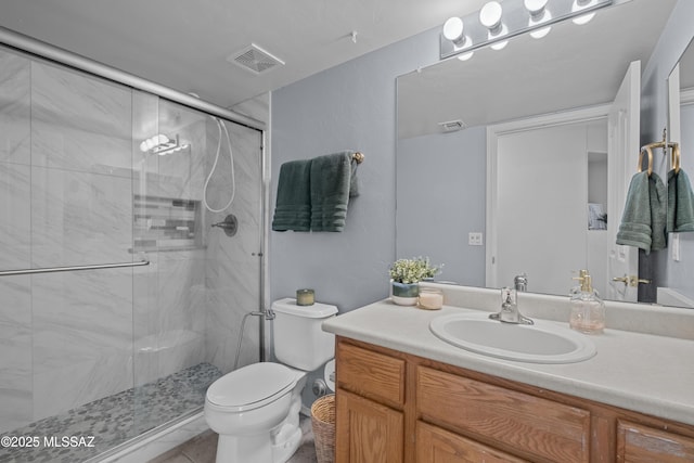 bathroom featuring vanity, a shower with shower door, and toilet