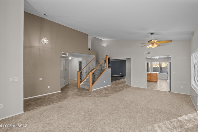 unfurnished living room featuring ceiling fan, light colored carpet, and high vaulted ceiling