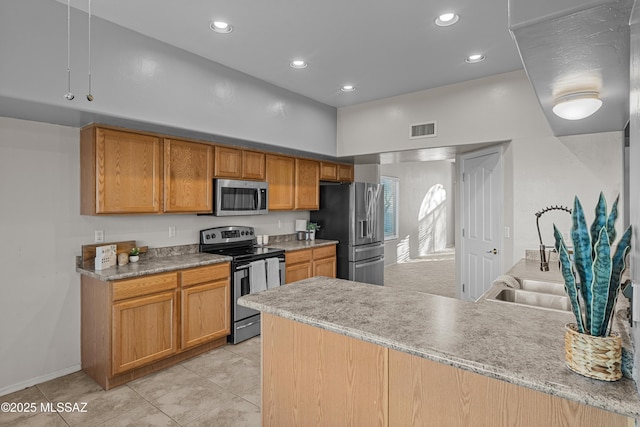 kitchen with appliances with stainless steel finishes, a towering ceiling, sink, light tile patterned floors, and kitchen peninsula