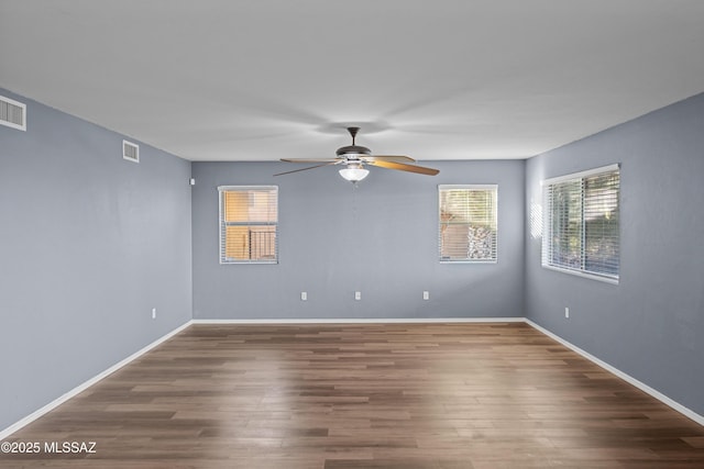 spare room with dark hardwood / wood-style floors and ceiling fan