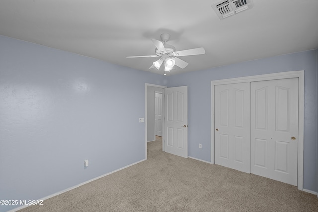 unfurnished bedroom with light carpet, ceiling fan, and a closet